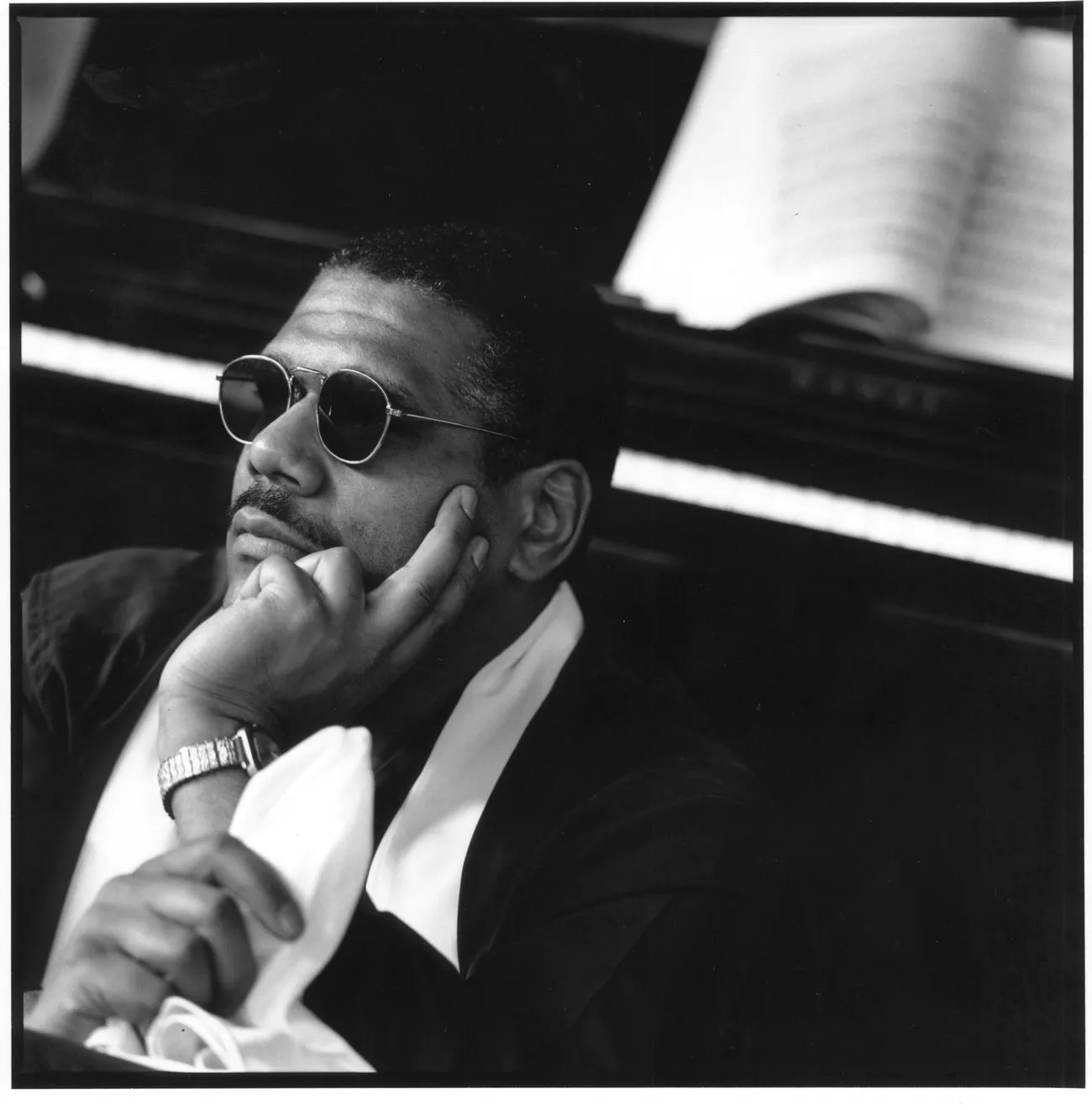 Donal Fox — black-and-white studio portrait, sunglasses, hand on chin