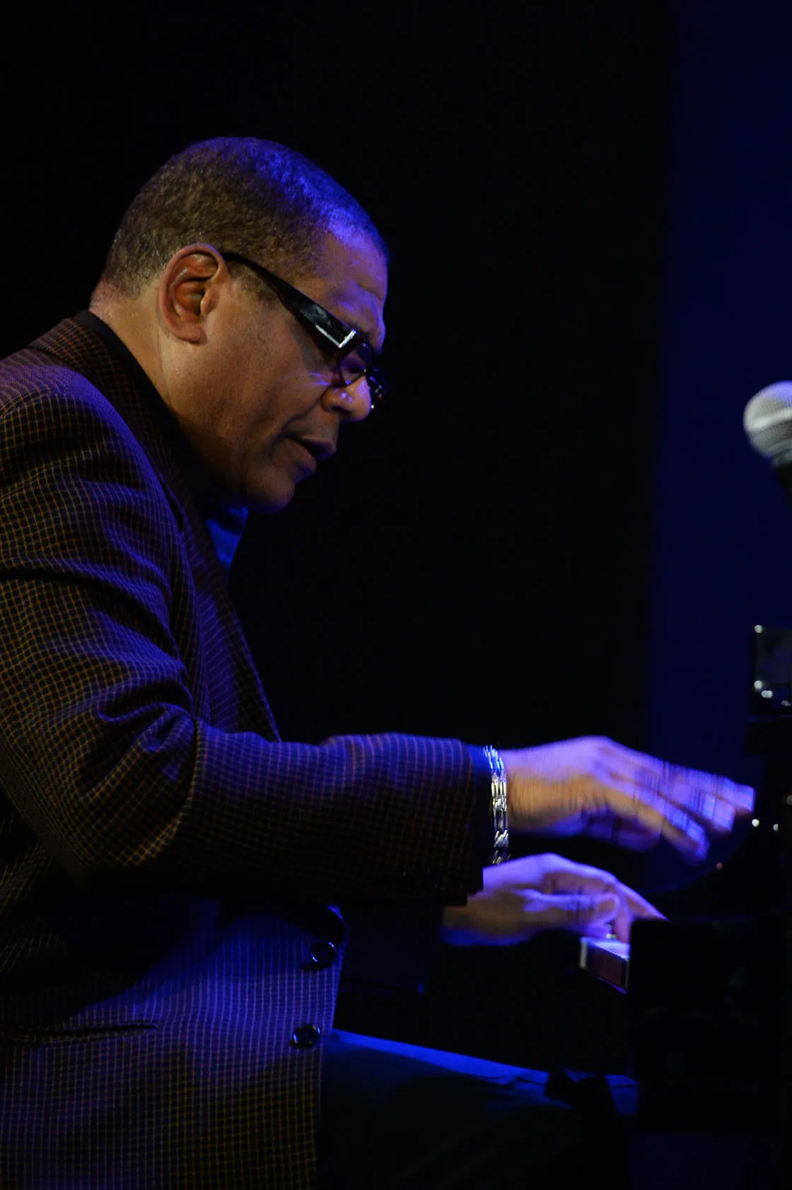 Donal Fox at the piano under blue stage light